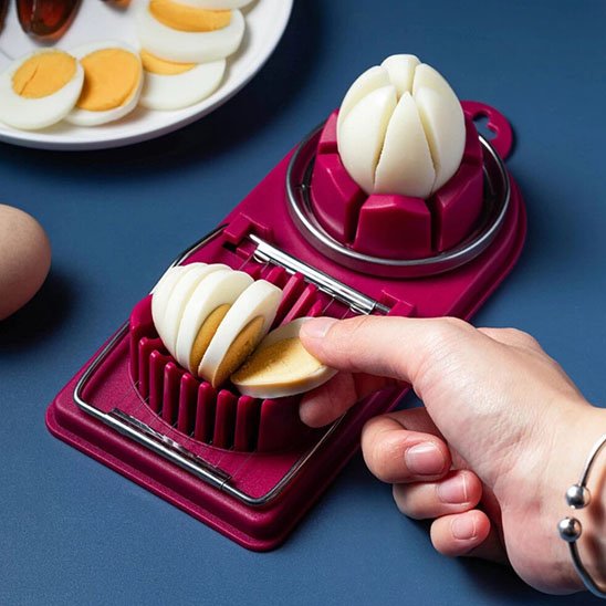 Coupe oeuf​ dans les main d'une femme qui coupe les oeufs 