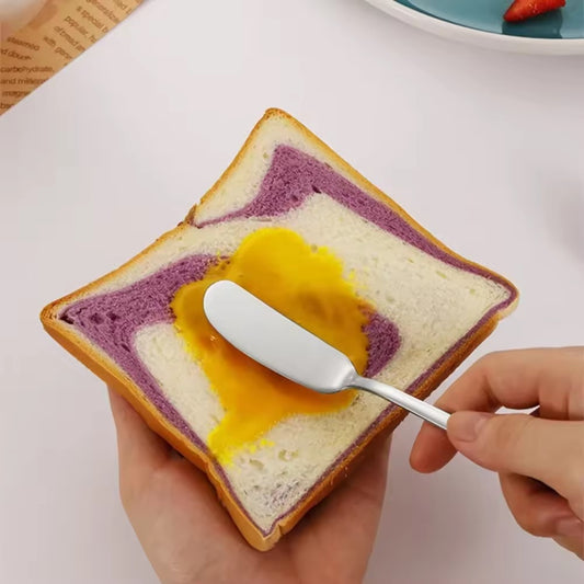 mettre de la confiture sur du pain avec un couteau à beurre 