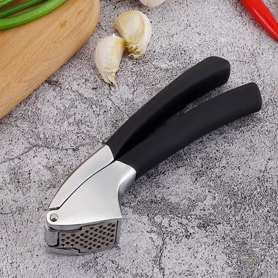 un presse ail noir sur une table de cuisine 