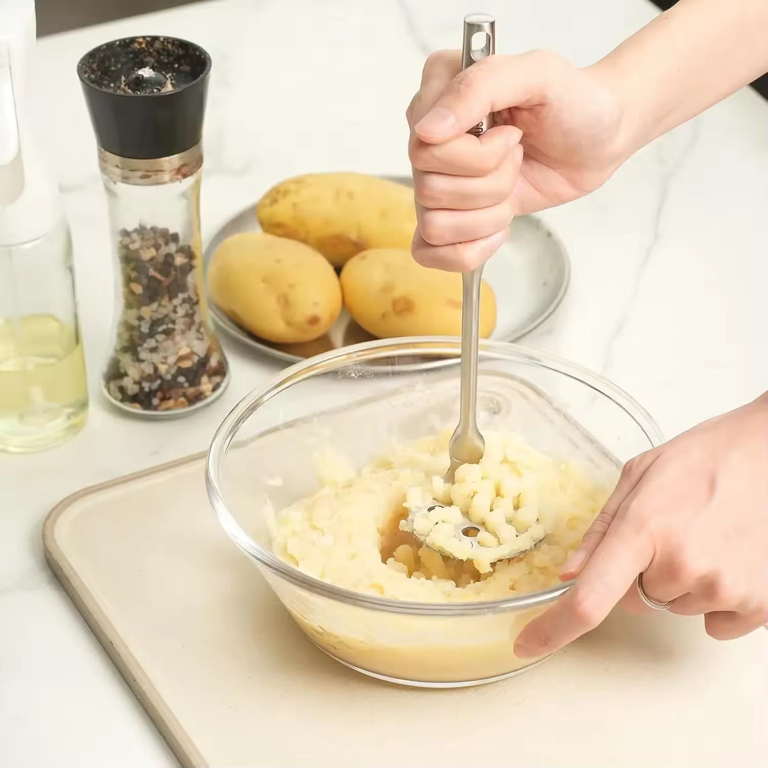 ecraser les pommes de terre avec un presse purée manuel 