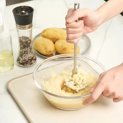 ecraser les pommes de terre avec un presse purée manuel 